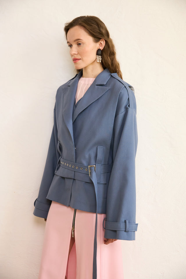 Woman wearing a blue jacket with a plain background