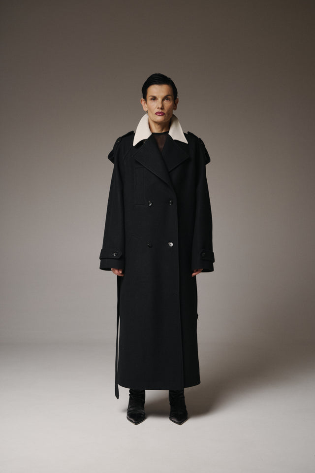 This Maxi Wool Coat offers a contemporary balance of structure, comfort, and understated luxury.

Crafted from 95% premium wool, it wraps you in warmth while maintaining a fluid, architectural silhouette. The contrasting collar inserts add a refined graphic accent, subtly elevating the timeless design.