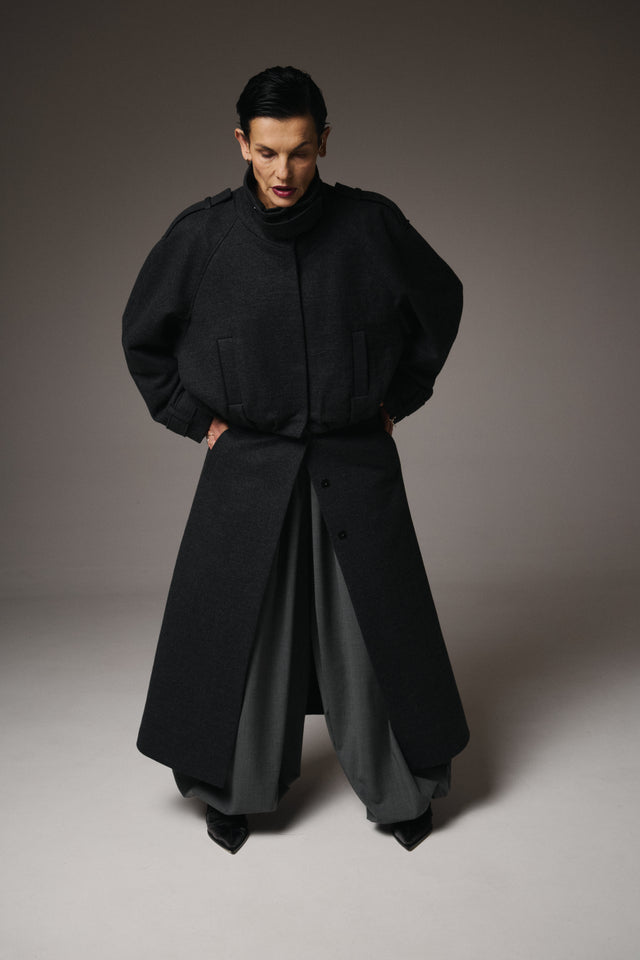 This Transformable Wool Bomber-Coat redefines versatility with modern tailoring and modular design.

Crafted from 95% fine wool, it offers warmth, structure, and a refined drape. Thanks to strategically placed zippers, this single piece can be transformed into three distinct garments — a maxi coat, a skirt, and a bomber jacket, giving you endless styling possibilities while maintaining a cohesive aesthetic.